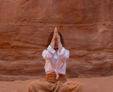 Personne en position de yoga, symbolisant l'enracinement et la connexion à son énergie vitale. La photo évoque l’harmonisation des chakras et l’ancrage énergétique.